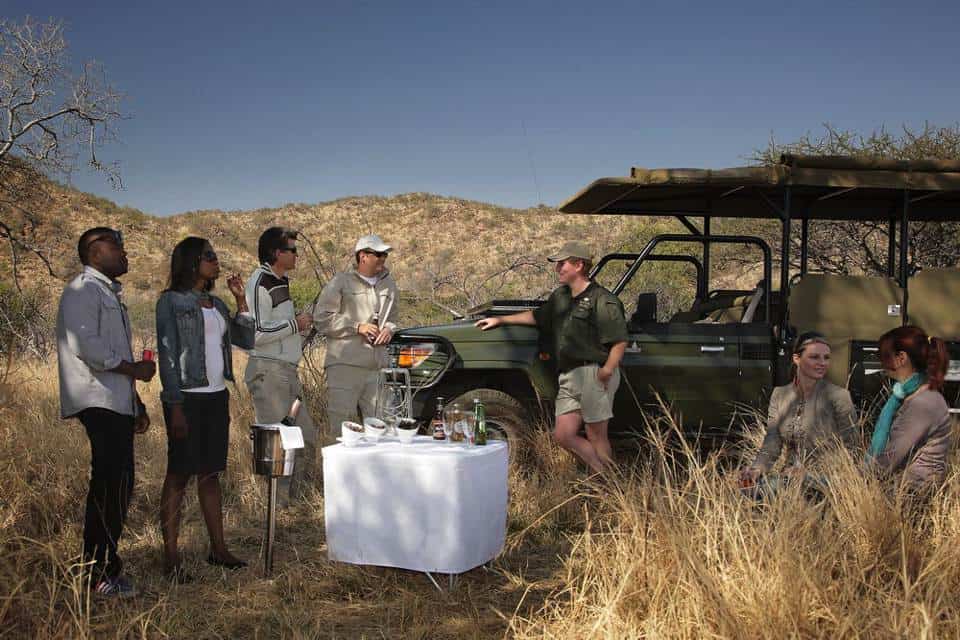 Tour guide explaining safari details to visitors in the African bush.